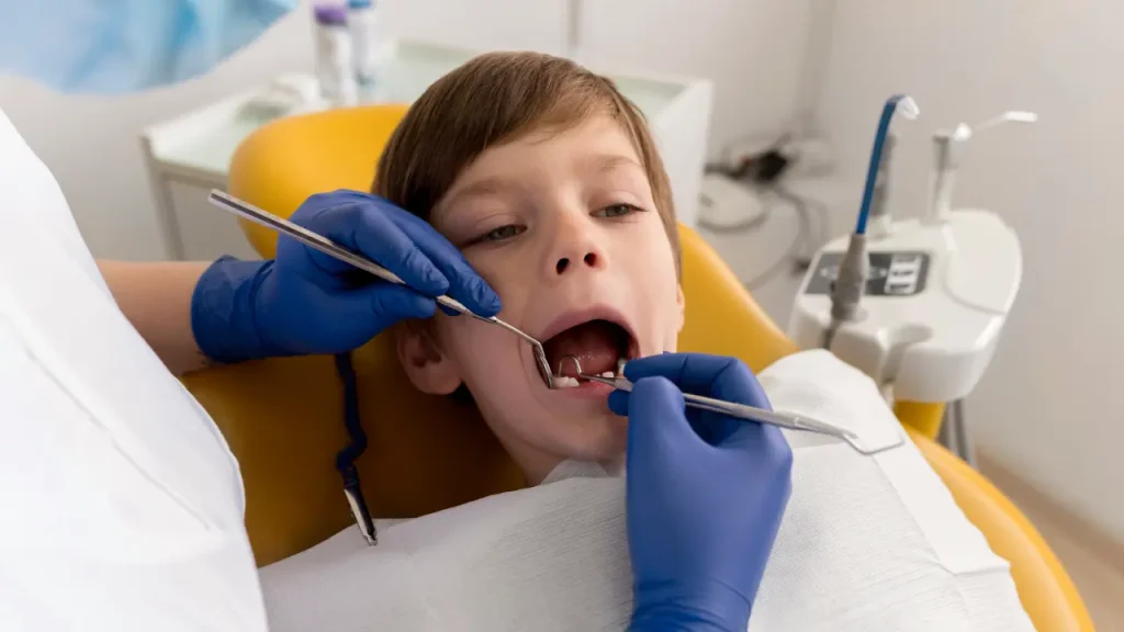 Pediatric dentist restoring a child's tooth with a dental filling during treatment in Dubai