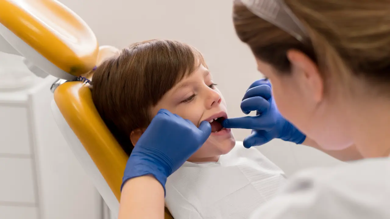 Pediatric dentist examining a child's teeth to evaluate for malocclusion