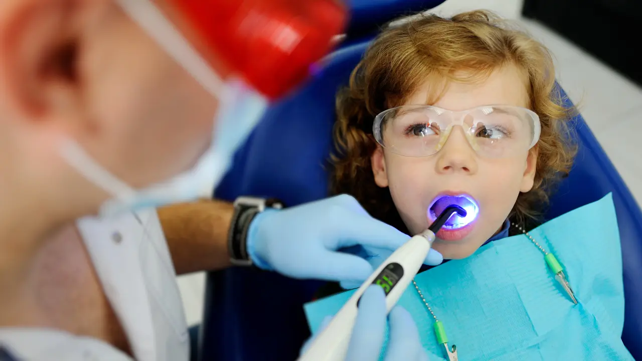 Child receiving a fluoride treatment during a dental visit