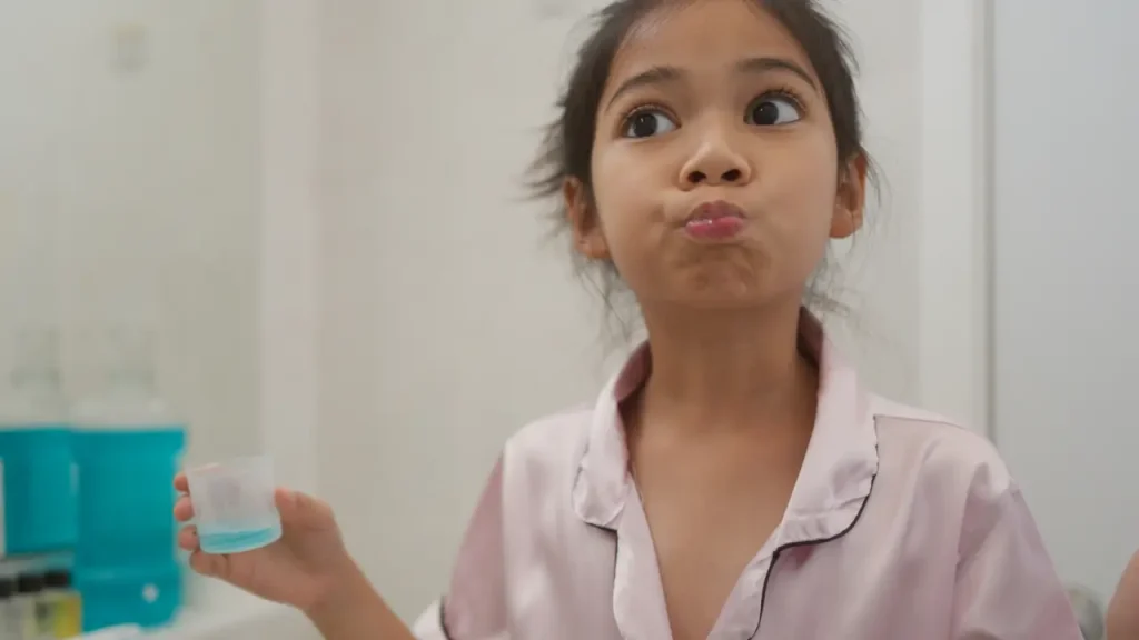 Child using mouthwash as part of a kids' oral hygiene routine