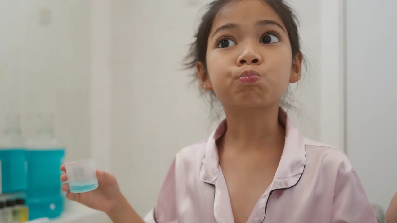 Child using mouthwash as part of a kids' oral hygiene routine
